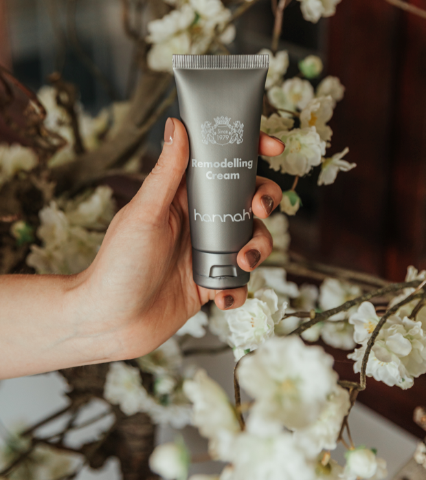 Hannah Modelling Cream in de hand, tussen witte bloesem